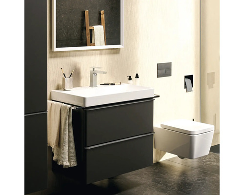 Salle de bain moderne avec lavabo, meuble sous-lavabo, miroir et toilettes.