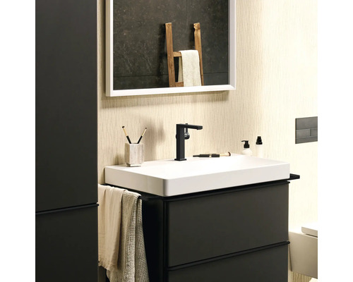 Badezimmer mit Waschbecken, Armatur, Spiegel und Ablageflächen