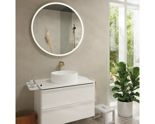 Modernes Badezimmer mit rundem Spiegel mit Beleuchtung, weißem Waschtisch und großem Fenster