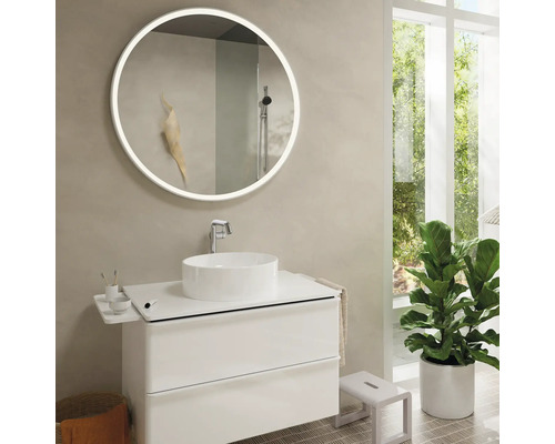 Modernes Badezimmer mit rundem Spiegel, Waschbecken und Pflanze