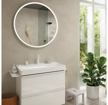 Salle de bains avec miroir rond éclairé, meuble sous-lavabo et plante d''intérieur
