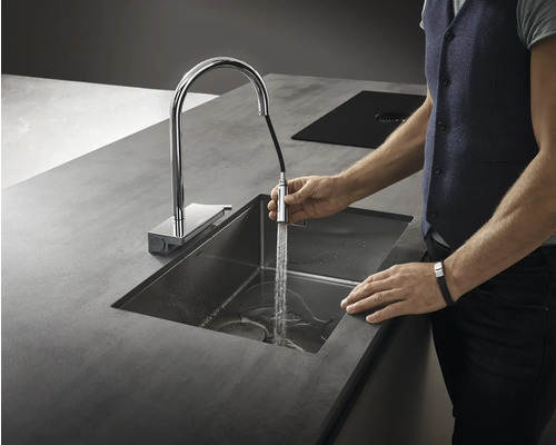 Eine Spüle mit Armatur auf einer Arbeitsplatte und eine Person, die Wasser laufen lässt.