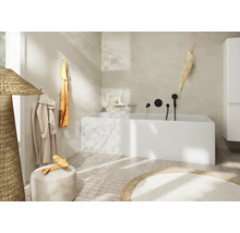 Helles Badezimmer mit Badewanne, Handtüchern und dekorativen Elementen für eine freundliche Atmosphäre.