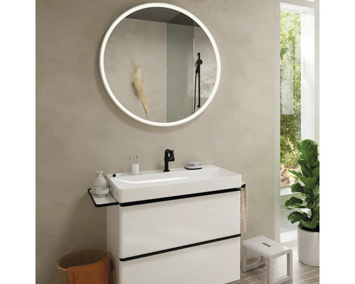 Modernes Badezimmer mit Waschtisch, beleuchtetem Spiegel und Dekoration