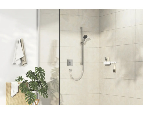 Espace douche avec pomme de douche, robinet, étagère et serviettes