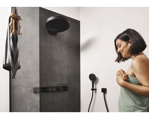 Dunkle Regendusche und Handbrause in einem modernen Badezimmer mit Frau