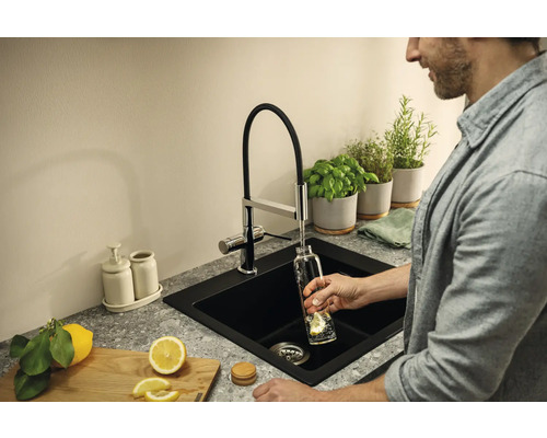 Évier noir avec robinet, herbes aromatiques et citron dans la cuisine