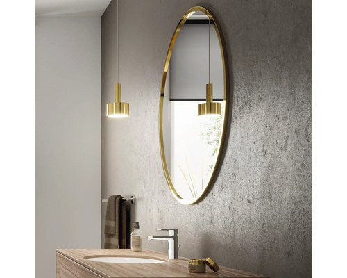 Modernes Badezimmer mit ovalem Spiegel, Waschtisch und Beleuchtung.