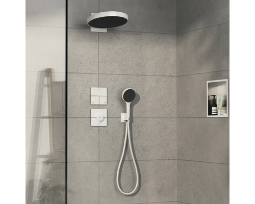 Robinet de douche avec pomme de tête, douchette à main et éléments de commande sur un mur gris