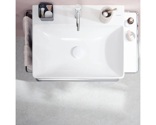 Aufnahme von oben eines weißen Aufsatzwaschbeckens mit Armatur, Seifenspender und Handtuchhalter