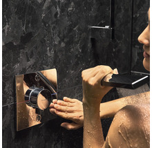 Frau bedient Duscharmatur im Badezimmer