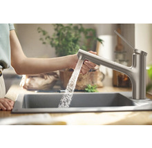 Küchenszene mit Spüle und Wasserhahn, aus dem Wasser läuft