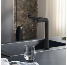 Robinet noir sur un évier avec un verre d''eau.