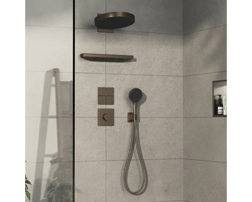 Ensemble de robinetterie de douche avec pomme de tête, douchette à main et éléments de commande sur un mur carrelé