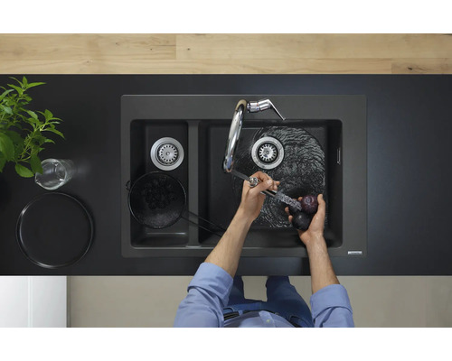 Image d''un évier double avec robinet et d''une personne lavant des prunes