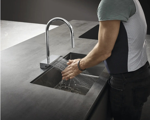 Eine Person wäscht ihre Hände unter einem Wasserhahn in einem Waschbecken.