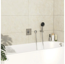 Salle de bain moderne avec baignoire blanche, robinetterie et produits de soins.