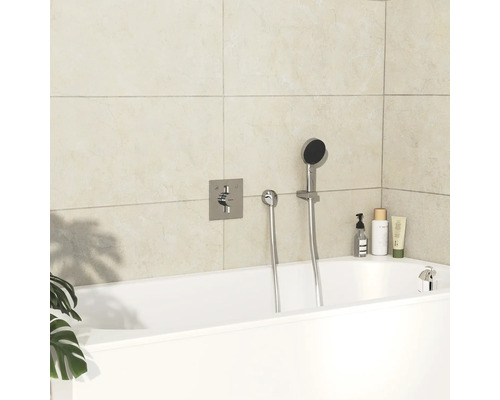 Salle de bain moderne avec baignoire blanche, robinetterie et produits de soins.