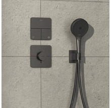 Duscharmatur mit Handbrause und Bedienelementen an gefliester Wand