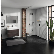 Badezimmer mit Waschtisch, Spiegel, Dusche und Ziegelwand