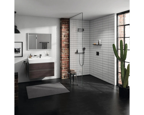 Salle de bains moderne avec lavabo, douche et mur en briques