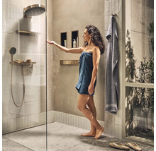 Helles Badezimmer mit Glasdusche, Regendusche und Frau mit Handtuch