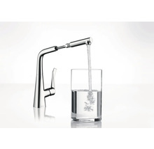 Robinet de cuisine en métal avec douchette extractible remplissant un verre d''eau