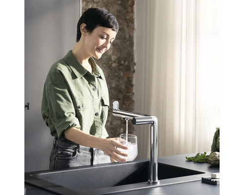 Femme remplissant un verre d''eau à l''évier avec robinet