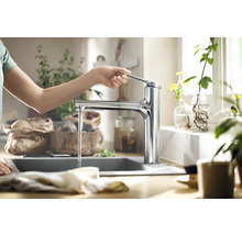 Bedienung einer Küchenarmatur mit Wasserauslauf in einem hellen Küchendesign.