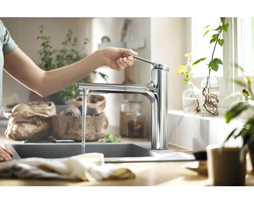 Utilisation d''un robinet de cuisine avec écoulement d''eau dans une cuisine claire.