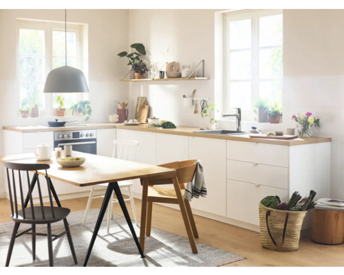 Cuisine claire avec table à manger, chaises et ustensiles de cuisine