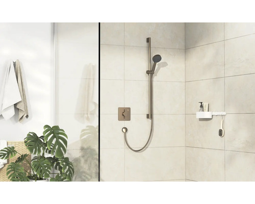Ensemble de douche avec douchette à main et thermostat carré dans une salle de bain lumineuse.