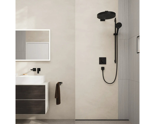 Salle de bains moderne avec meuble sous-lavabo, miroir avec éclairage et robinetterie de douche en noir.