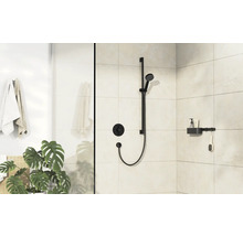 Salle de bains avec ensemble de douche noir, tablette et plante d''intérieur.