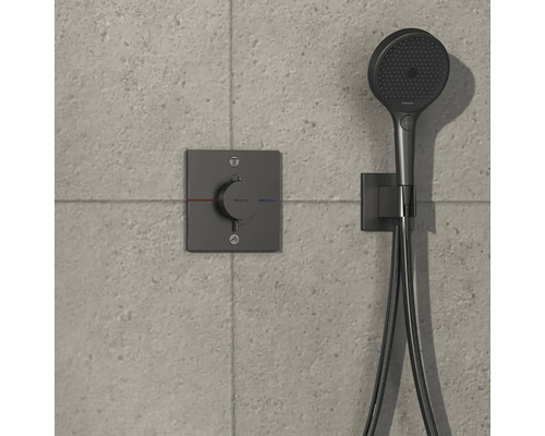 Brausegarnitur mit Thermostat und Handbrause an einer grauen Wand