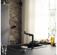 Scène de cuisine avec évier et robinet noirs devant une décoration de fenêtre.