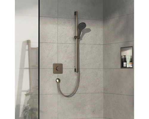 Robinet de douche avec douchette à main et étagère dans une cabine de douche carrelée