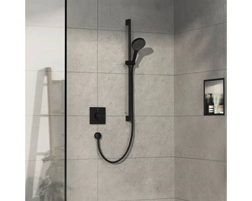 Dusche mit schwarzer Duschstange, Handbrause und Thermostatbatterie an gefliester Wand