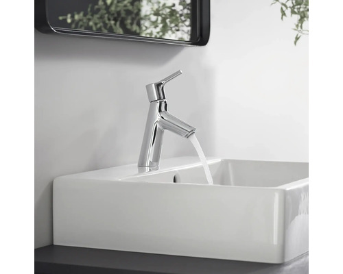 Verchromter Waschtischmischer auf einem Waschbecken mit laufendem Wasser