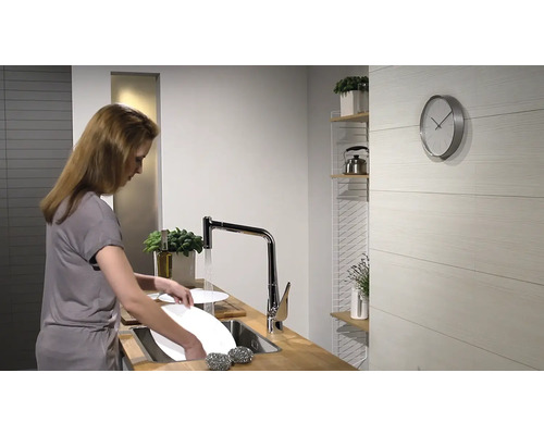 Frau spült Geschirr in einer hellen Küche mit Spültischarmatur