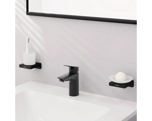 Badezimmer-Szene mit Waschbecken, schwarzer Armatur, Seifenschale mit Seife und Zahnputzbecher mit Zahnbürste