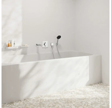 Salle de bains avec baignoire, robinetterie et étagères de rangement pour les articles de toilette.