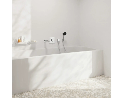 Salle de bains avec baignoire, robinetterie et étagères de rangement pour les articles de toilette.