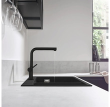 Robinet de cuisine noir avec évier dans une cuisine lumineuse.