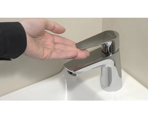 Robinet mitigeur monocommande dans la salle de bain avec main