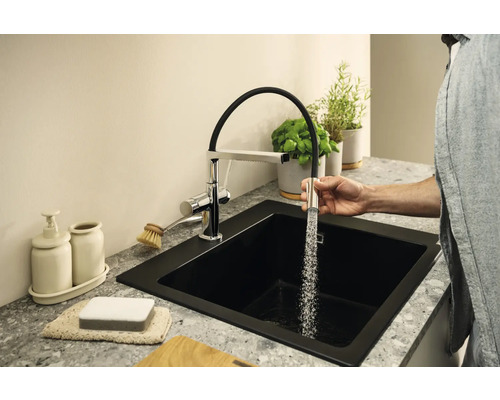Scène de cuisine avec évier noir et robinet avec douchette extractible