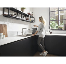 Cuisine moderne avec évier, robinet et étagères au design minimaliste.