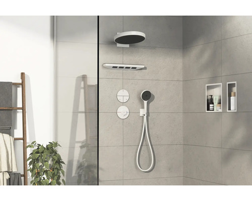 Espace douche avec pomme de tête, douchette à main et surfaces de rangement dans le mur