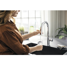Femme remplissant un verre avec un robinet dans la cuisine