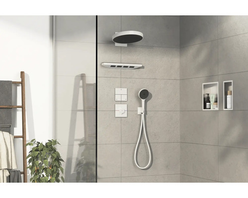 Salle de bains moderne avec pommeau de douche, douchette, commandes et niches de rangement.